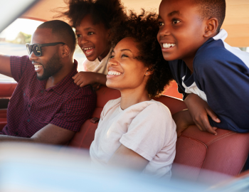 family of four smiling in car